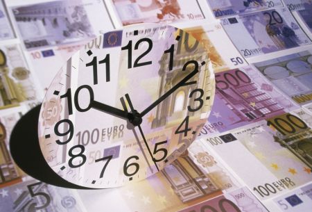 zegar z nadrukiem banknotów euro plus tło z euro